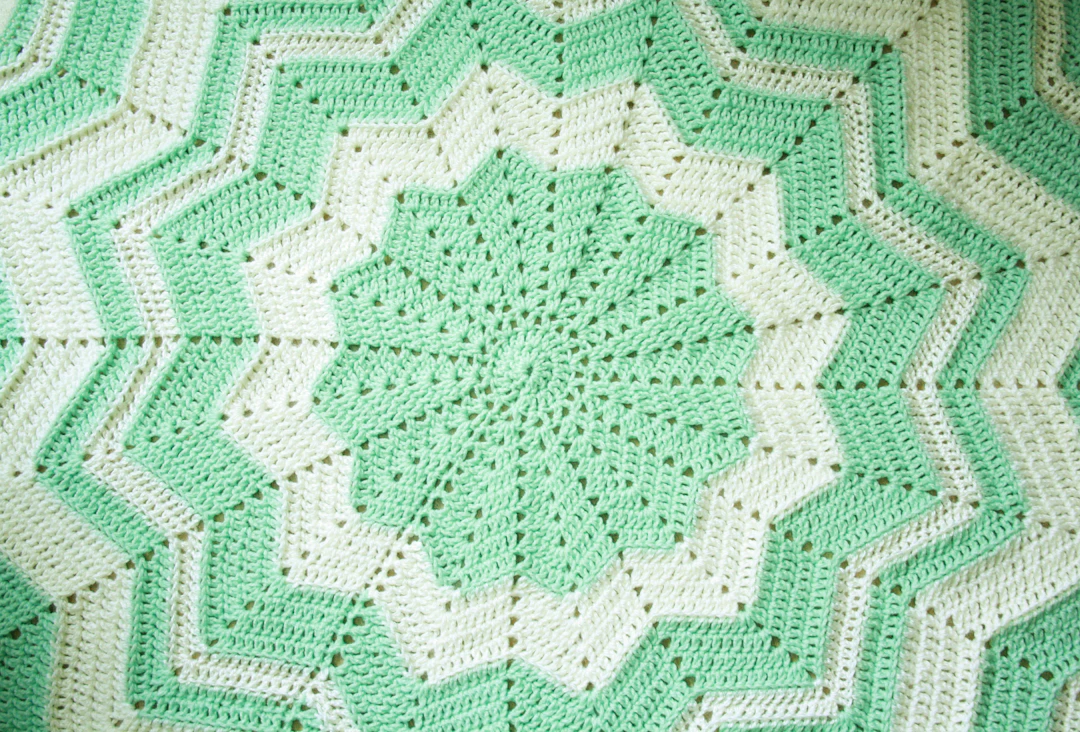 Handmade crochet blanket on bed